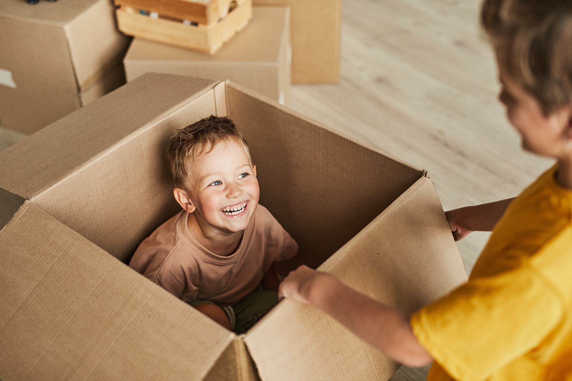Kid Playing in Cardboard Box