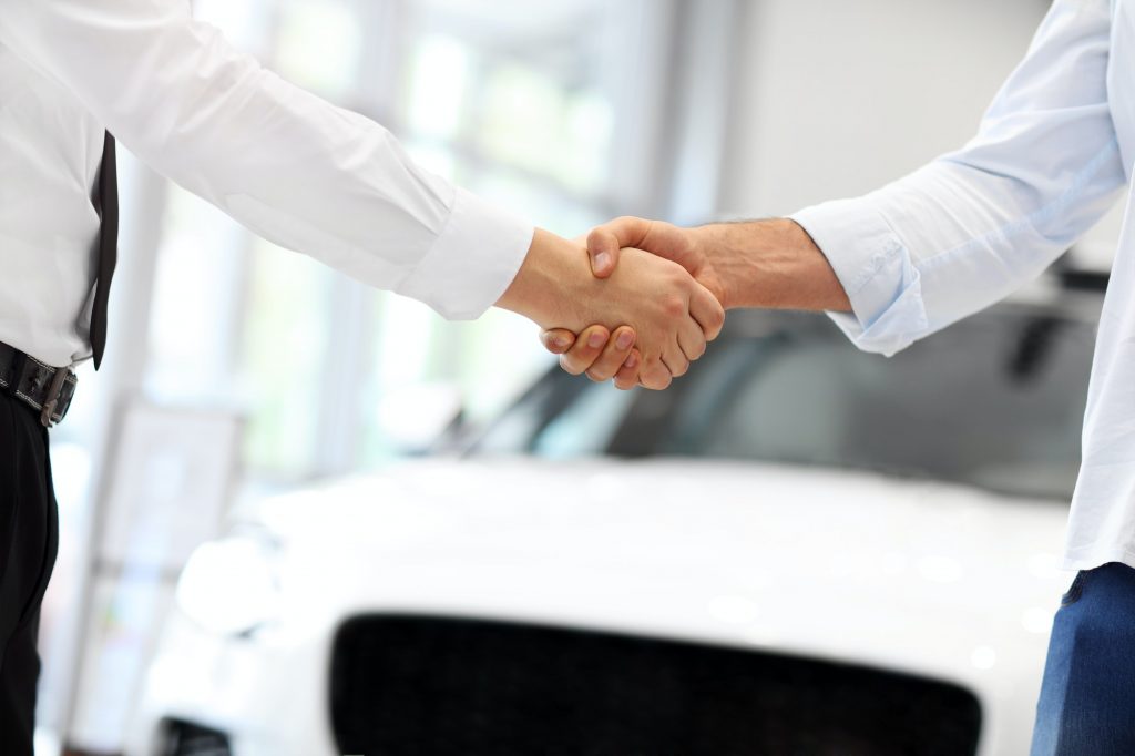 Midsection of young couple buying new car